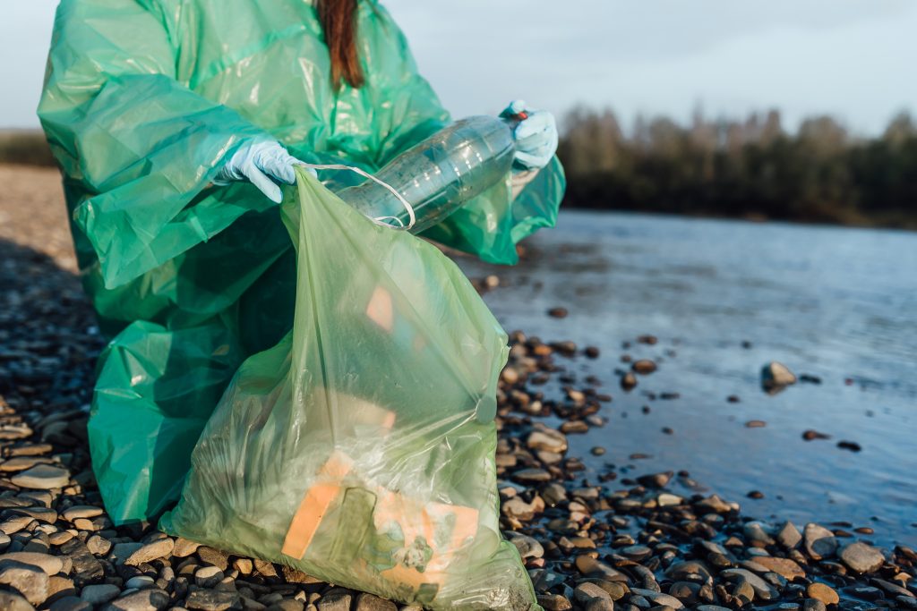 Woman picking up empty of bottle plastic ,volunteer concept .